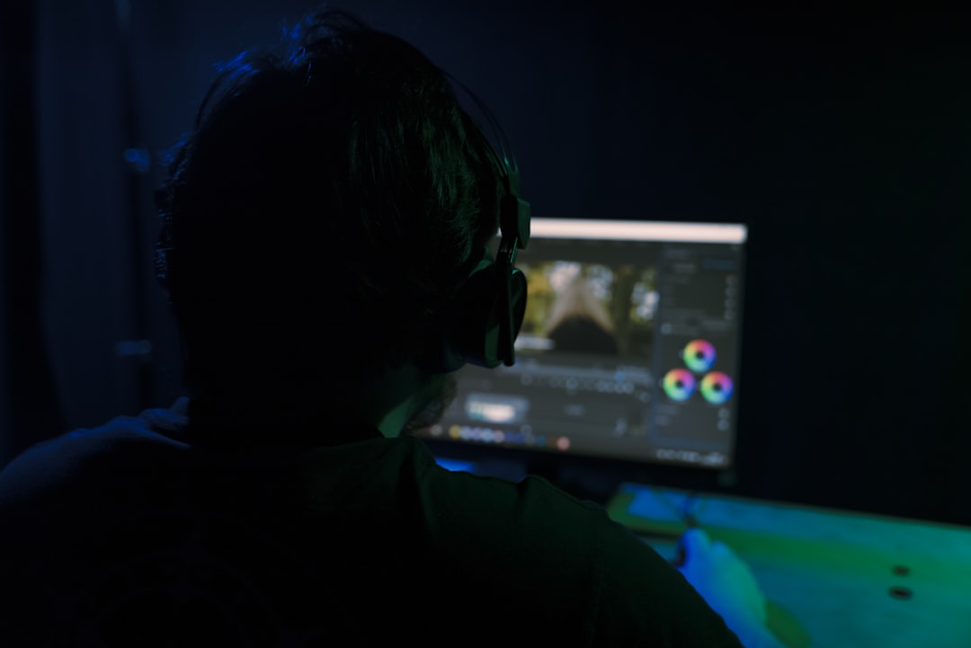 a man sitting in front of a computer monitor,