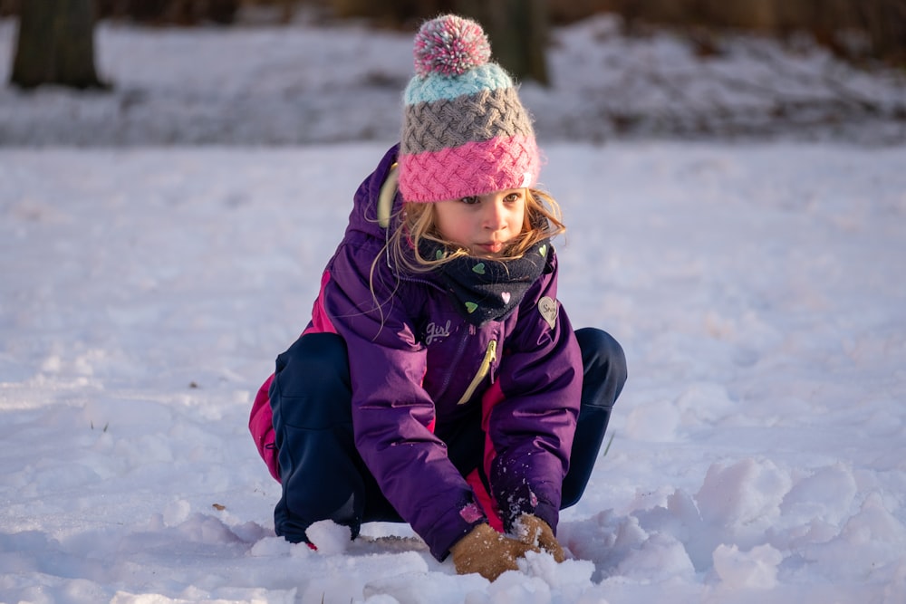 a little girl is playing in the snow