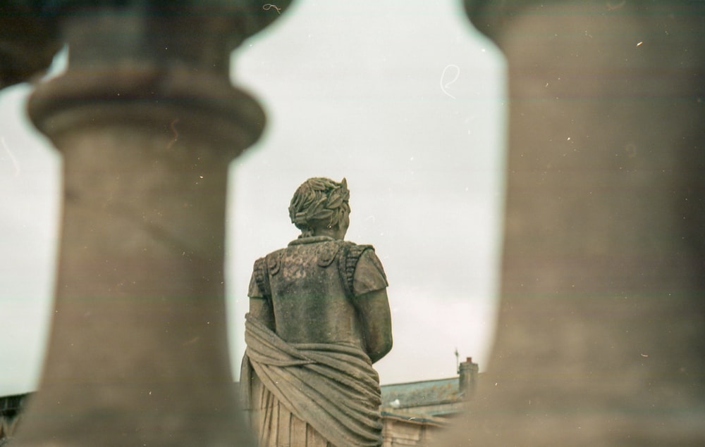 a statue of a woman standing between two pillars