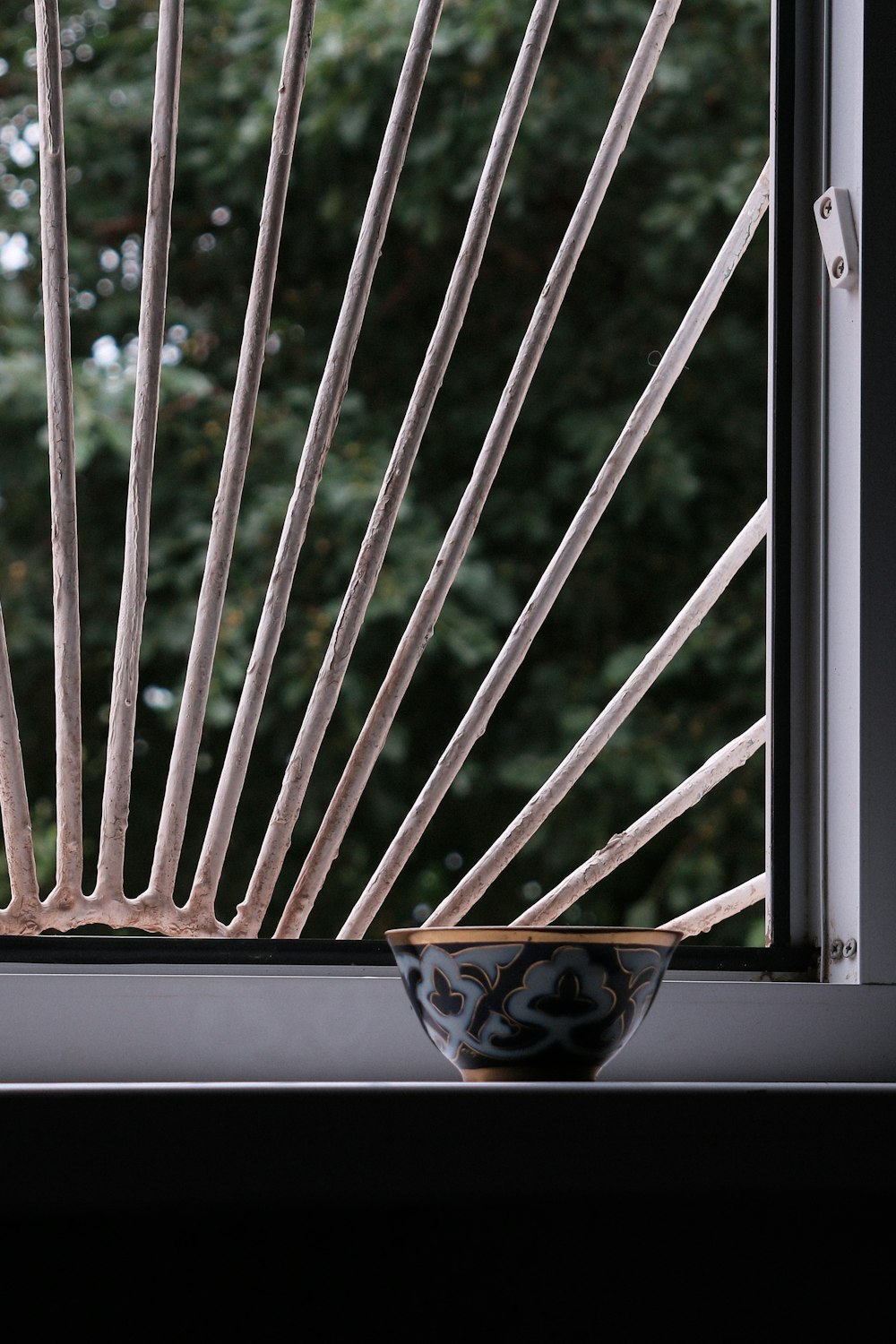 a black and white bowl sitting on top of a window sill