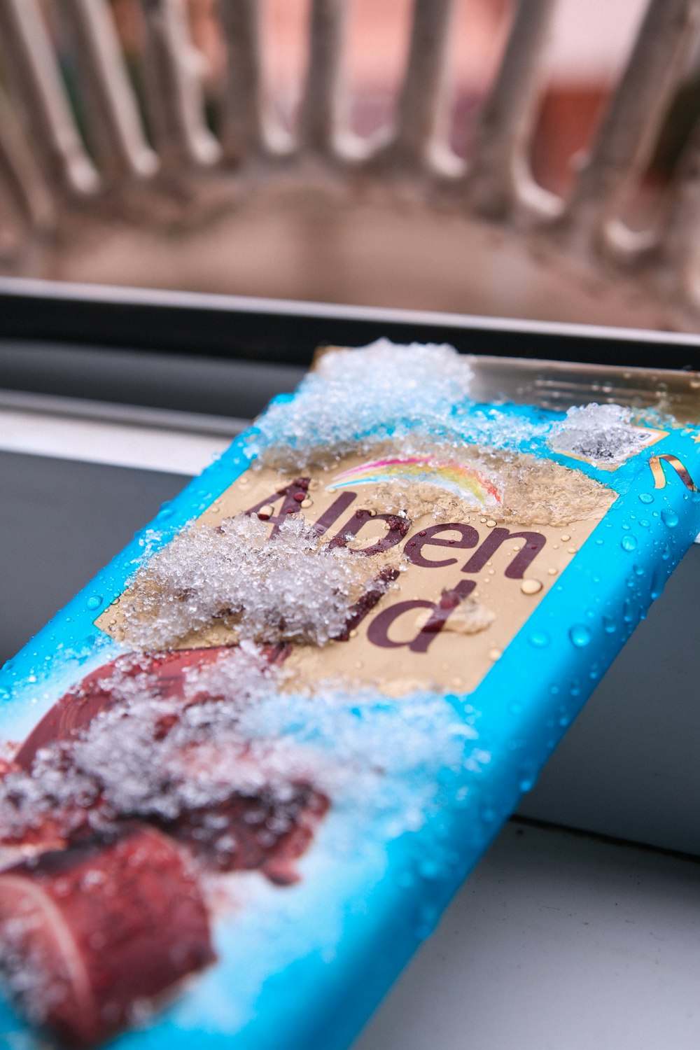 a box of frozen strawberries sitting on top of a window sill