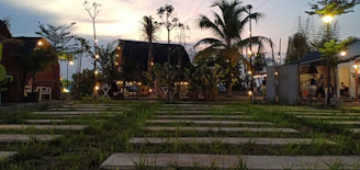 A cozy boutique resort nestled among lush greenery with warm lighting at dusk.