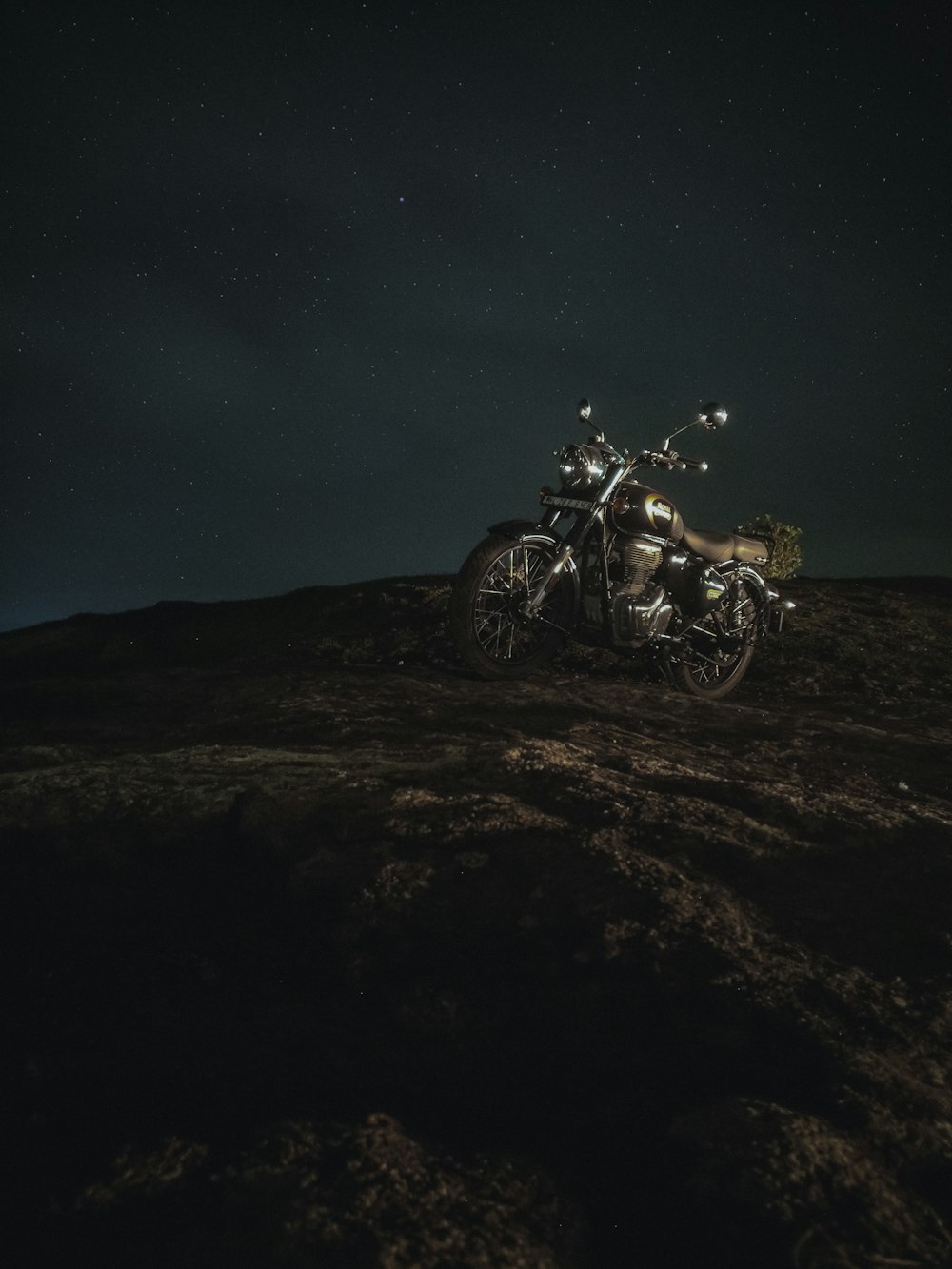 a motorcycle parked on top of a hill at night