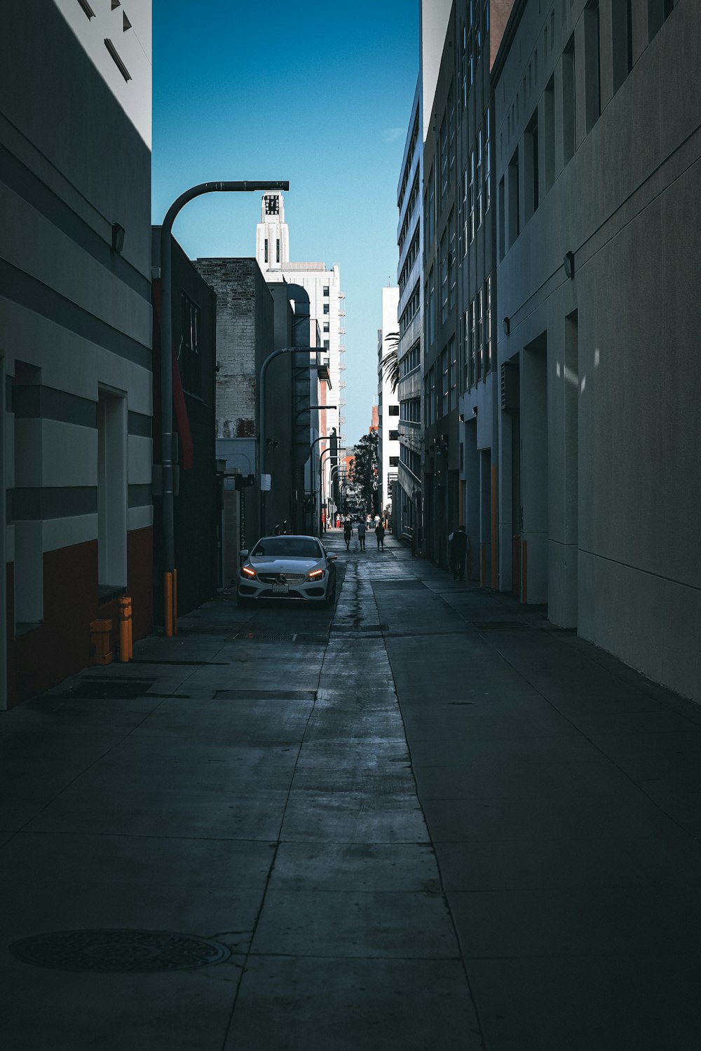 a car parked on the side of a street next to tall buildings