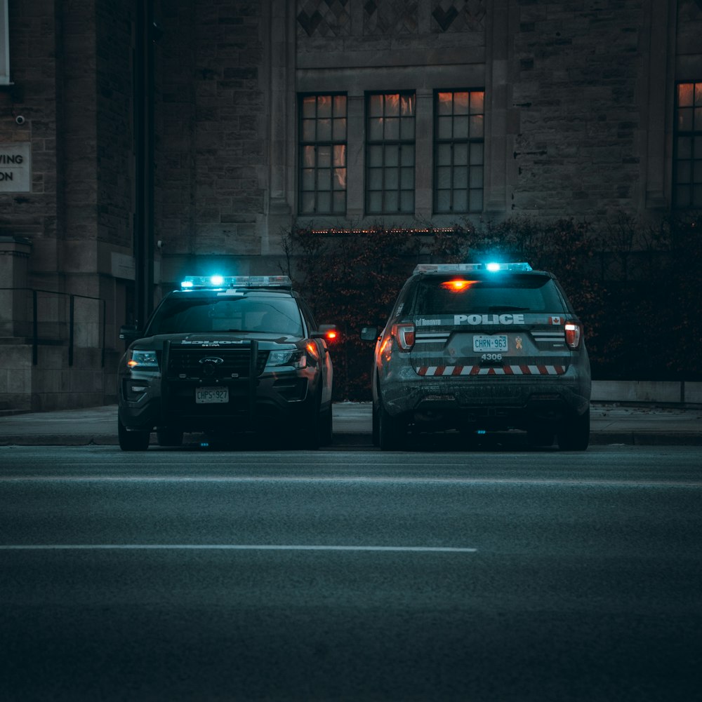two police cars parked on the side of the road