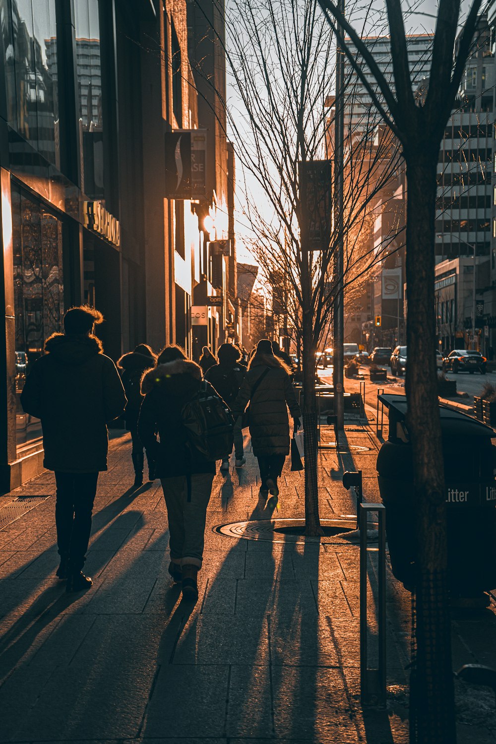 a group of people walking down a street next to tall buildings