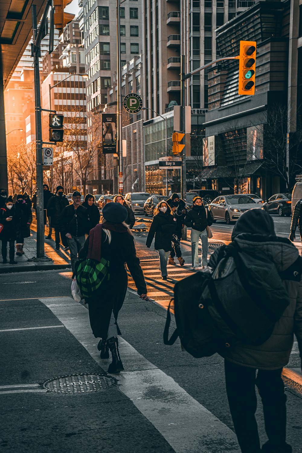 a group of people walking down a street next to tall buildings