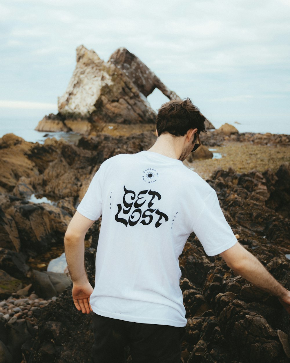 a man standing on top of a rocky beach