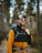 A happy customer using a travel backpack on a hiking trail.
