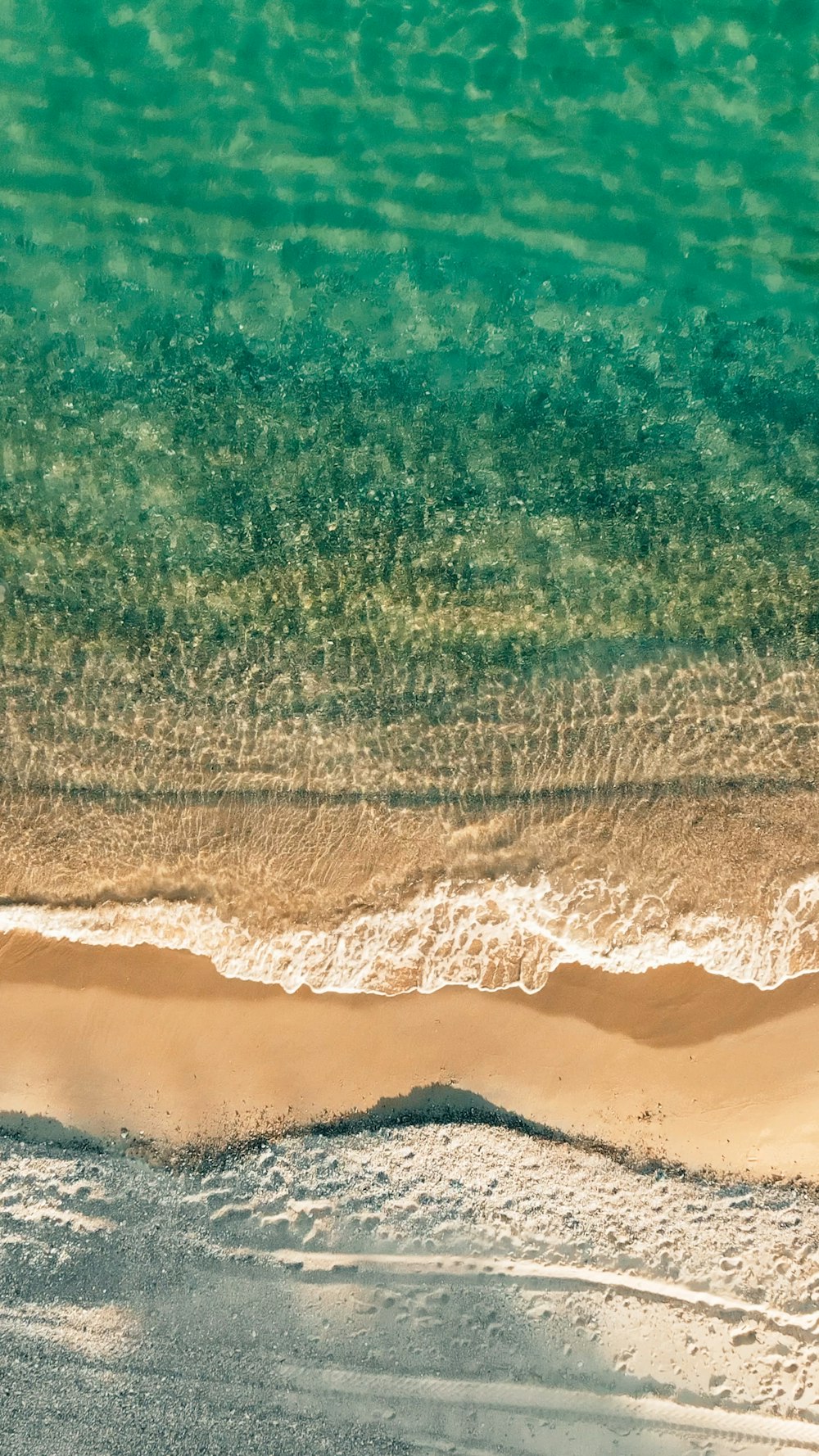 an aerial view of a sandy beach and ocean