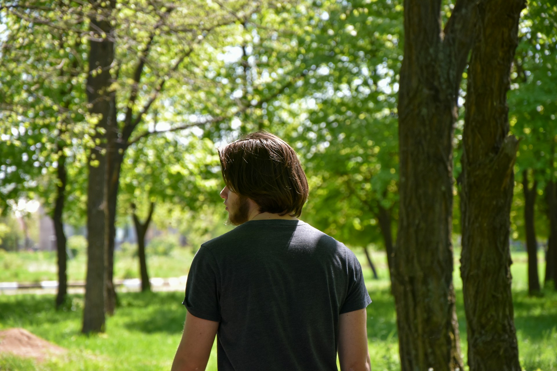a man standing in a park with a frisbee
