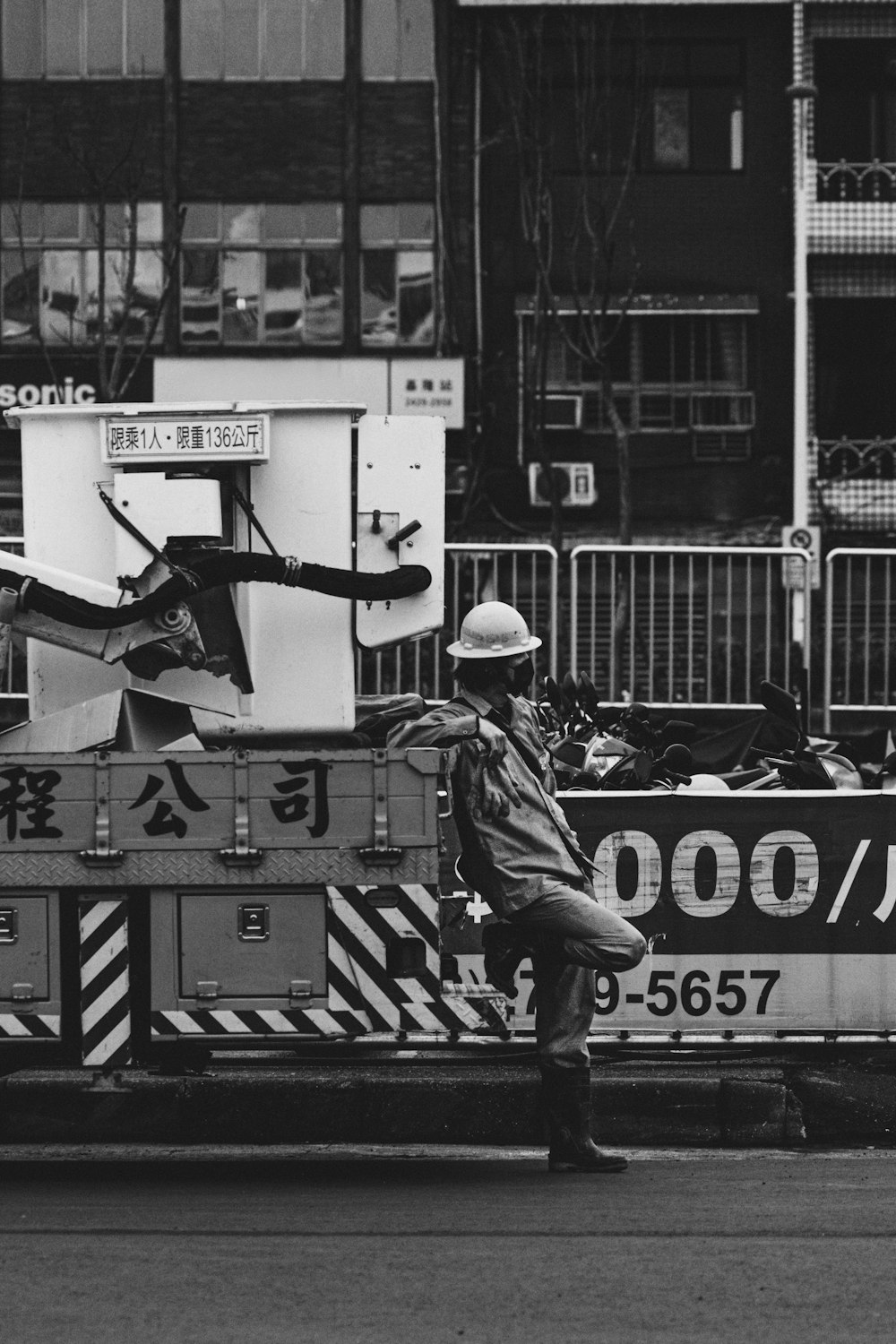 a black and white photo of a man standing in front of a fire truck