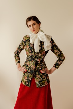 a woman in a floral jacket and red skirt