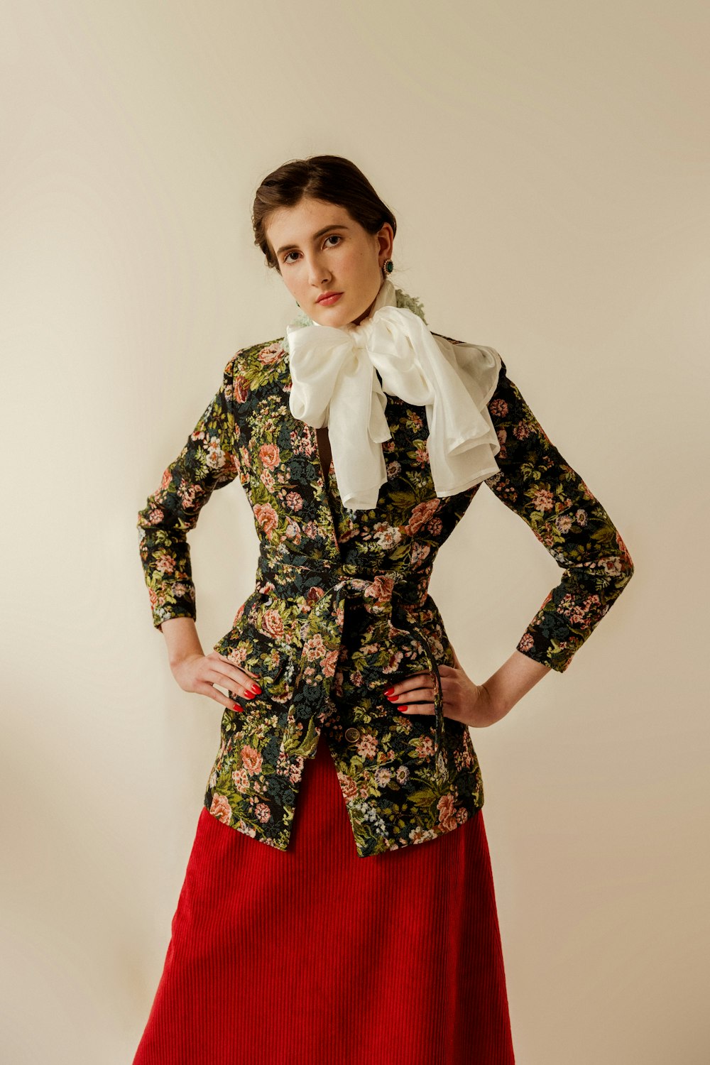 a woman in a floral jacket and red skirt