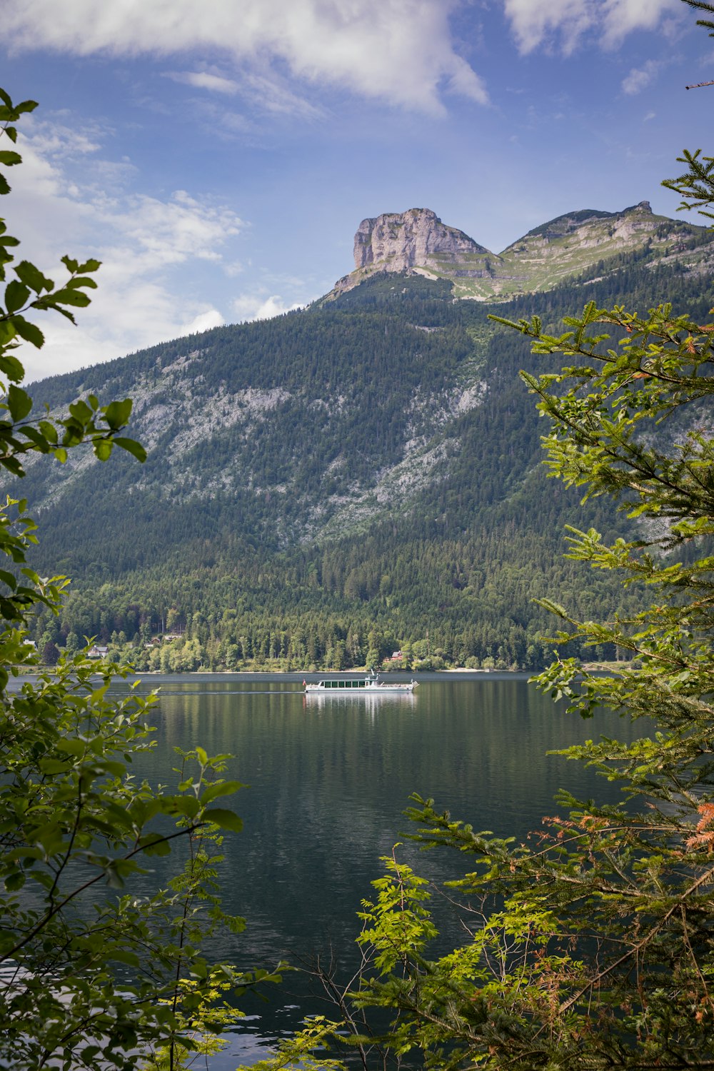 a lake surrounded by mountains with a boat in the water