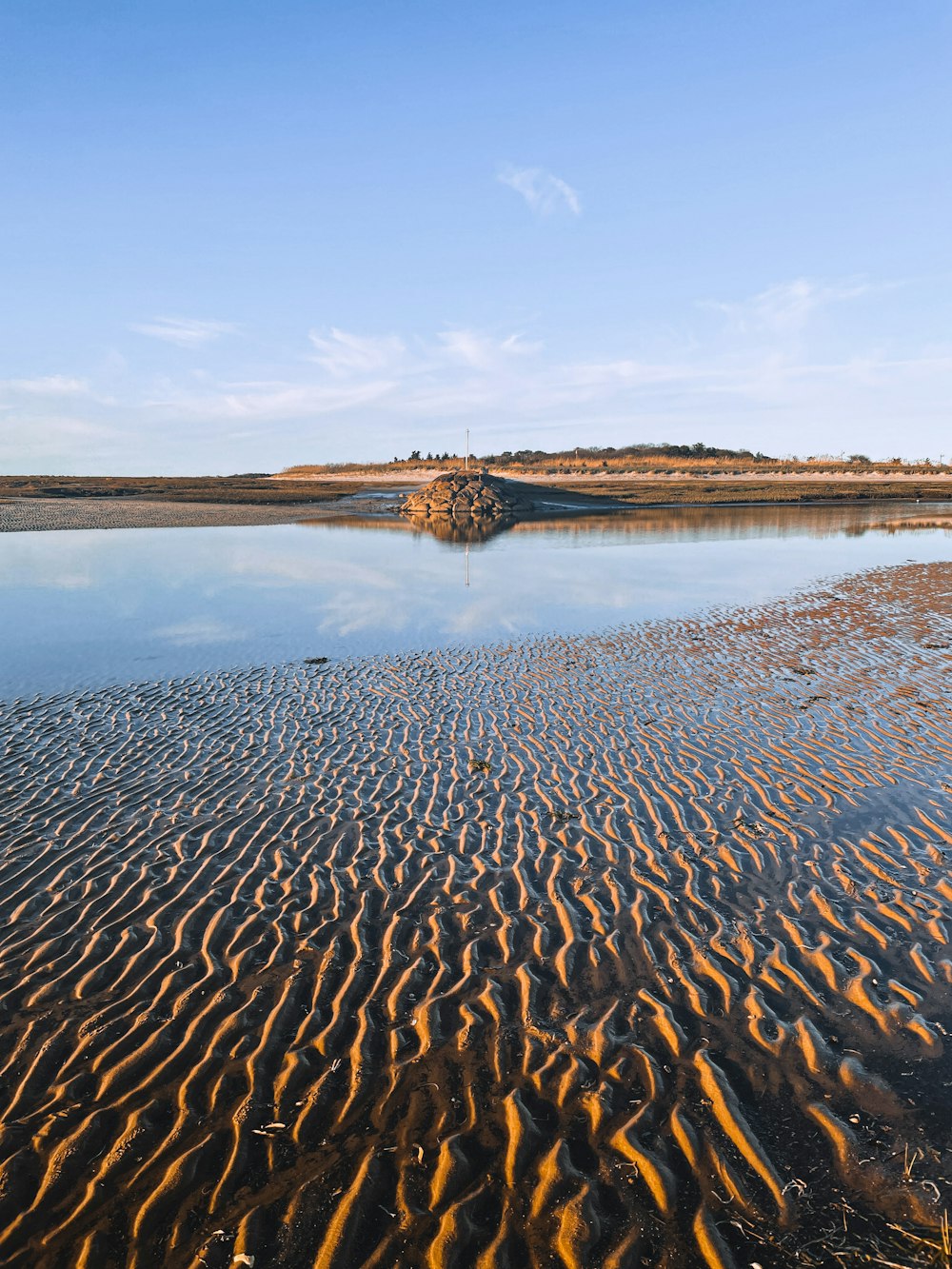 a body of water surrounded by sand dunes