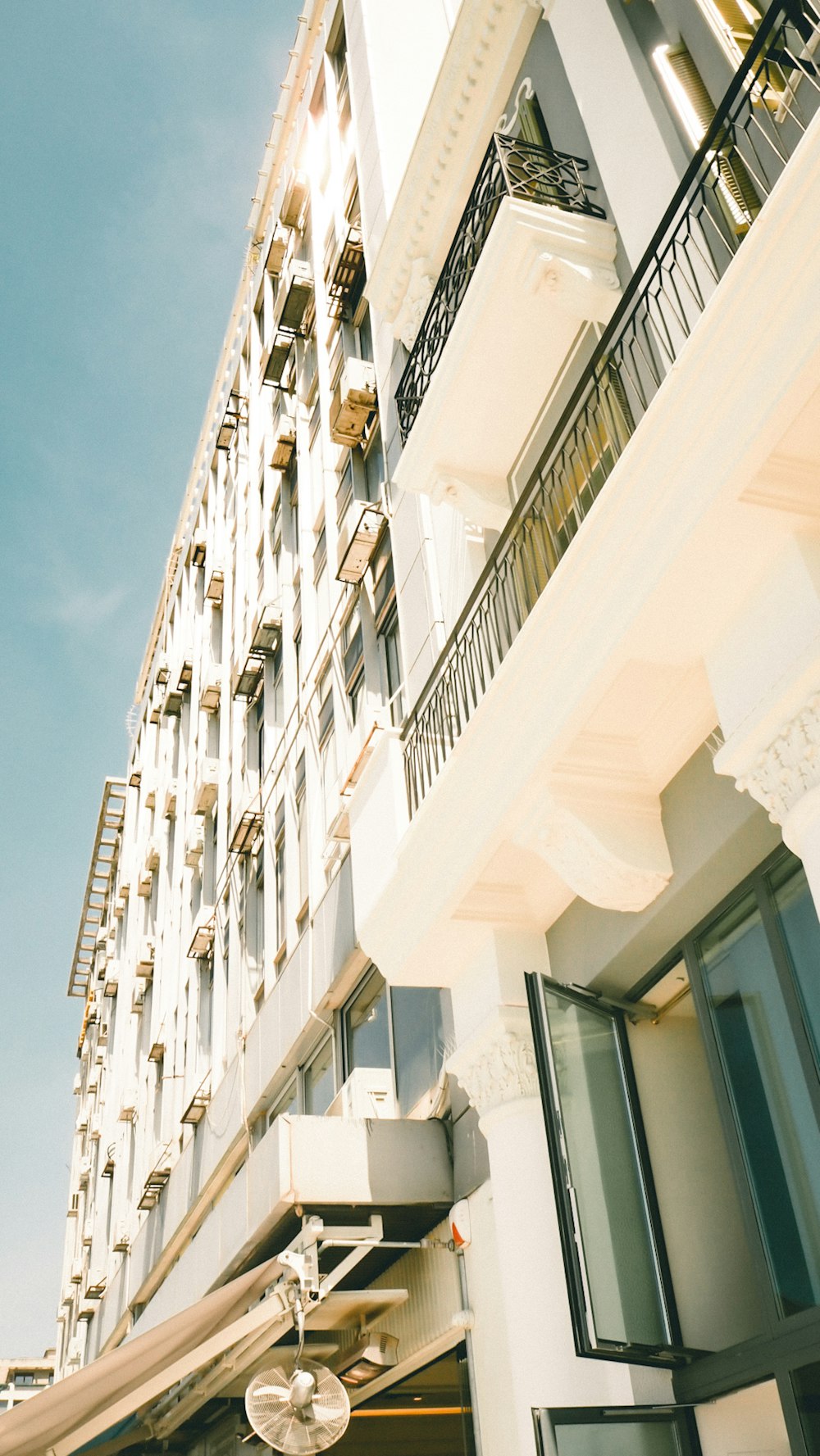 a tall white building with balconies and balconies