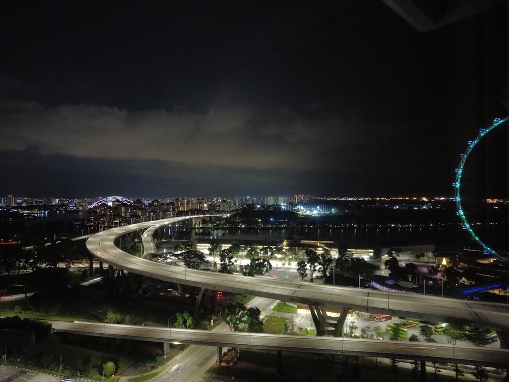 a view of a city at night with a ferris wheel in the distance