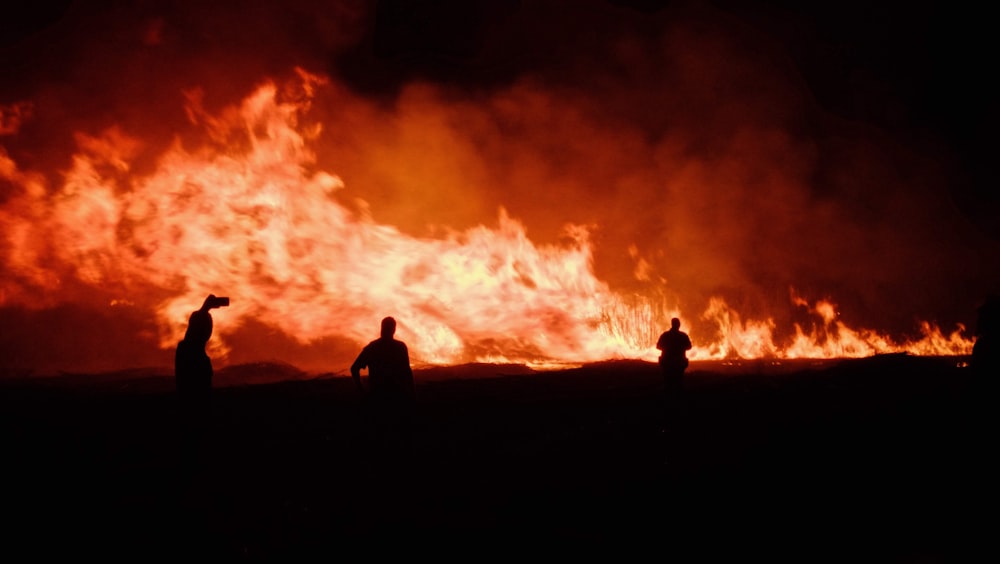 a group of people standing in front of a fire