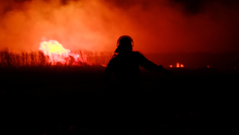 a person standing in front of a fire