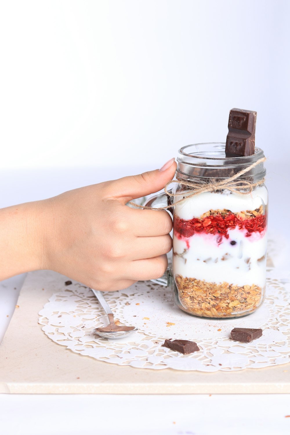 a person holding a mason jar filled with food