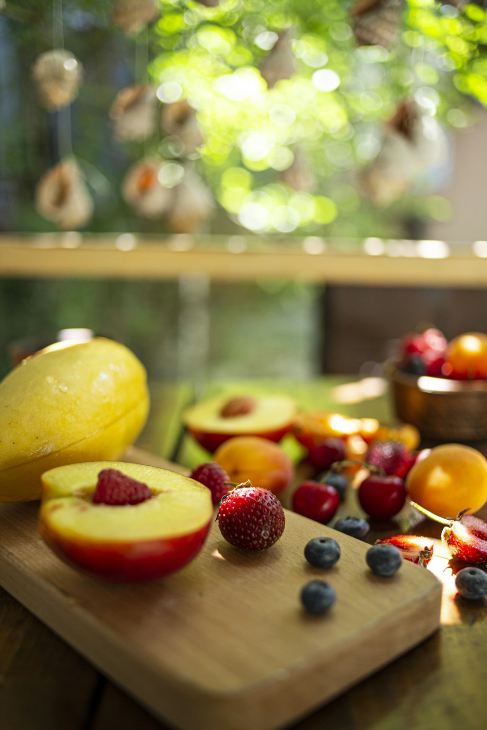 a wooden cutting board topped with fruit on top of a table