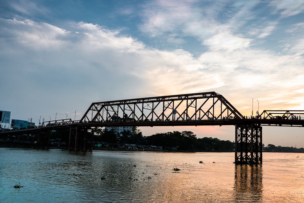 a bridge over a body of water with buildings in the background