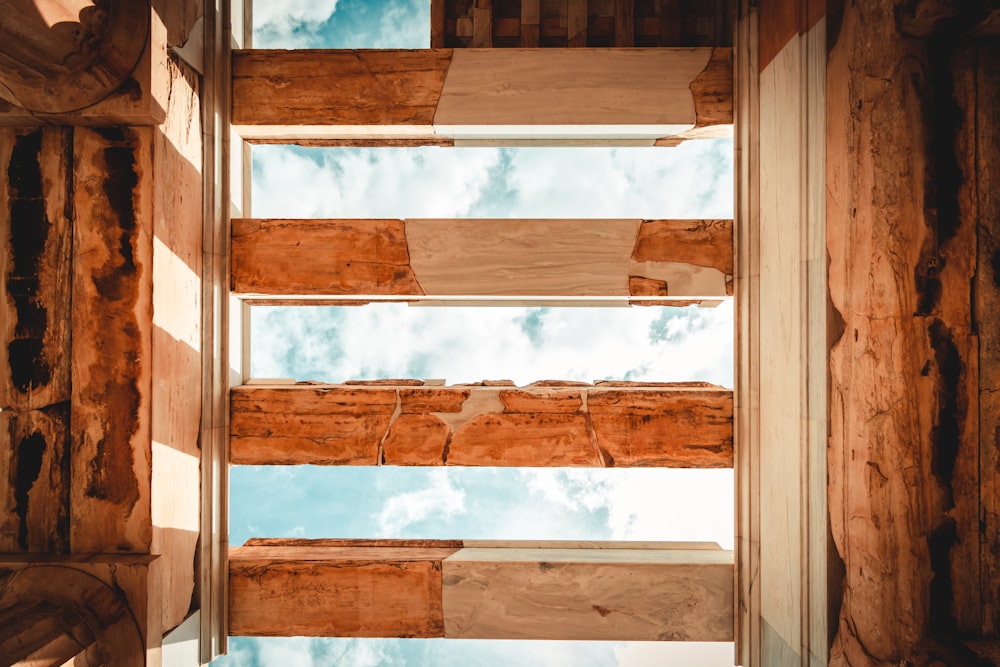 una ventana en una estructura de madera con el cielo al fondo