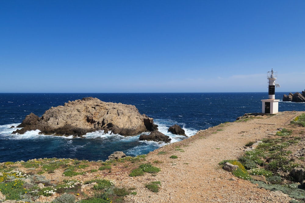 a lighthouse on a rocky cliff overlooking the ocean