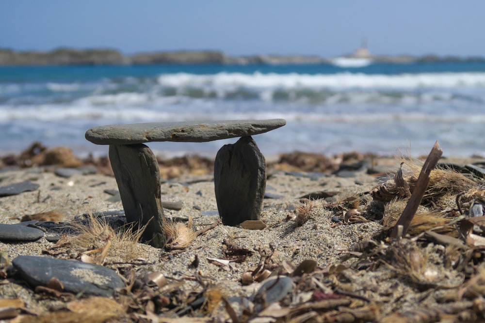 Un banco de piedra sentado en la parte superior de una playa de arena