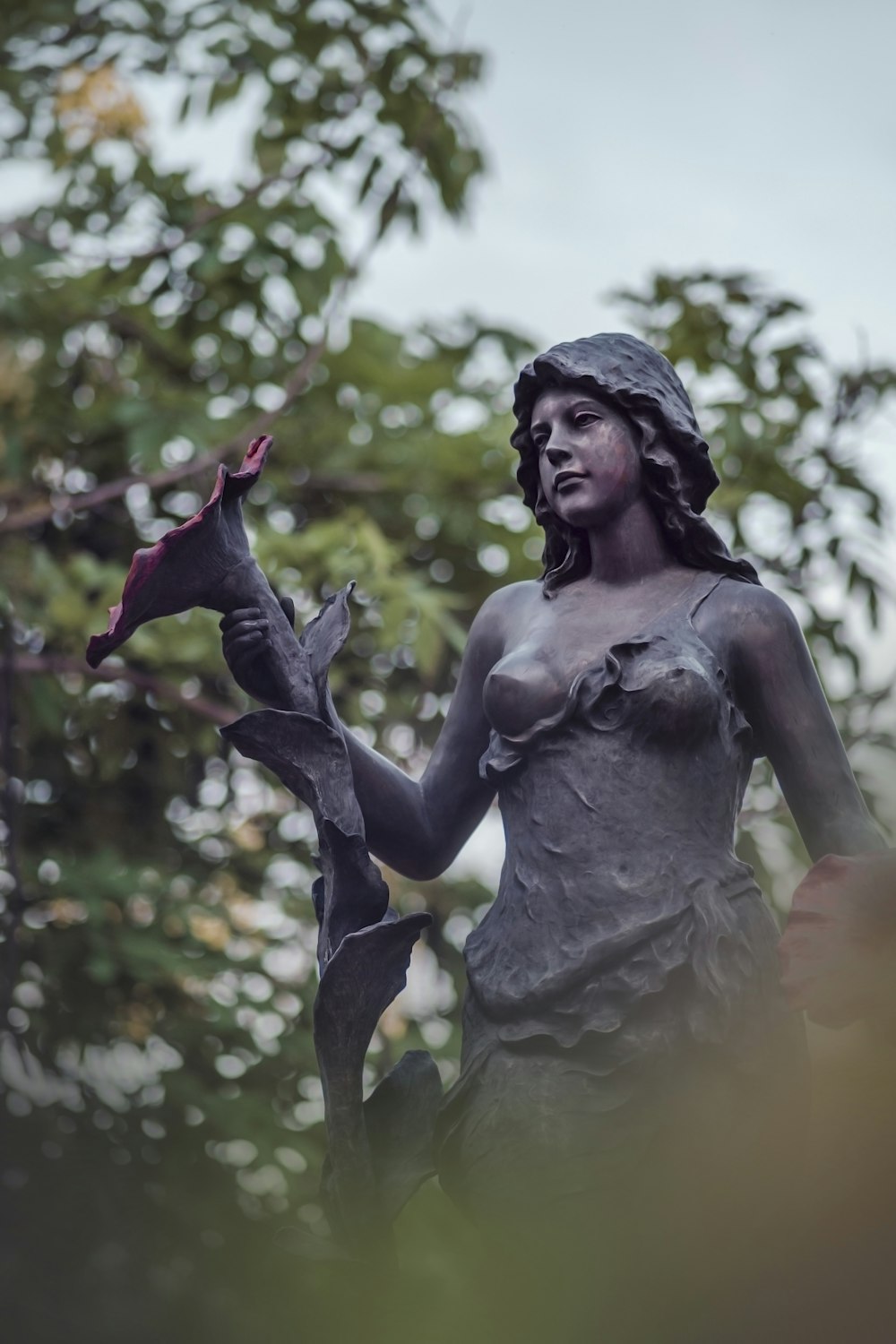 a statue of a woman holding a flower