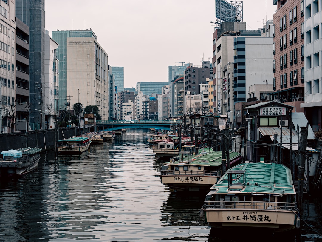 a small boat in a body of water with a city in the background,