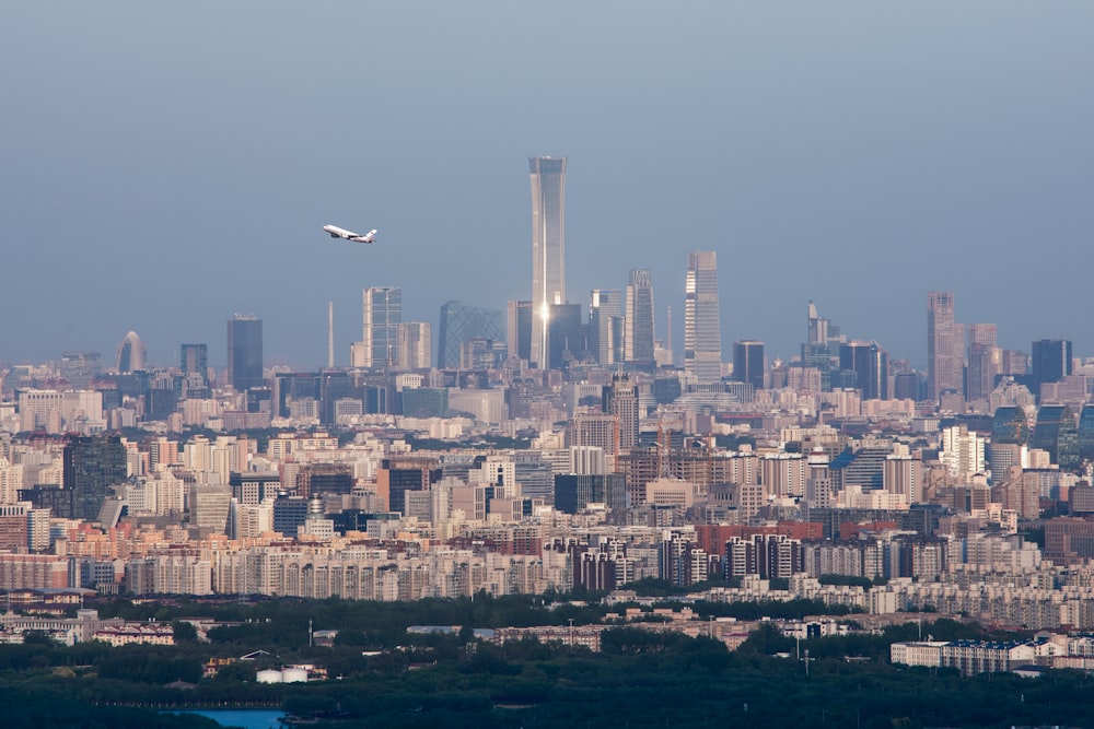 a plane flying over a city with tall buildings