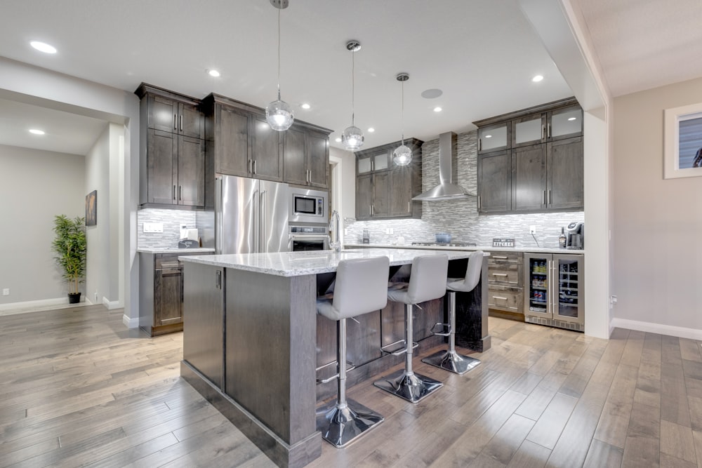 a large kitchen with a center island and bar stools