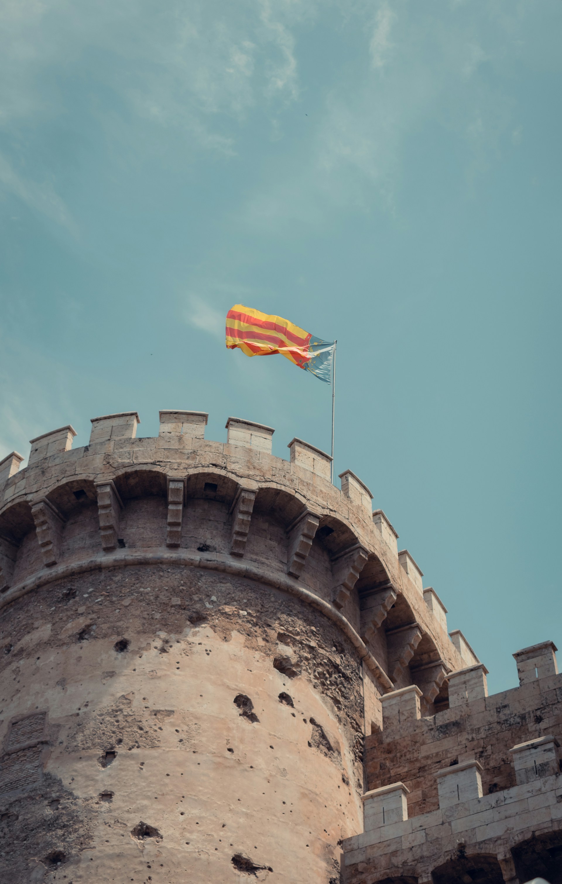 a yellow and red flag flying on top of a castle