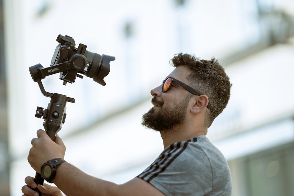 a man holding a camera and a tripod