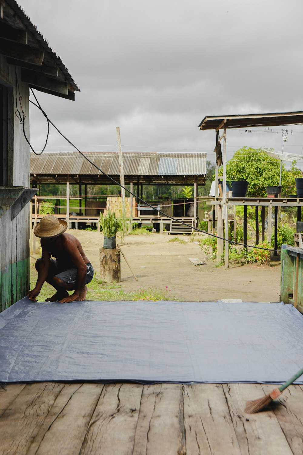 a man kneeling down on top of a blue tarp