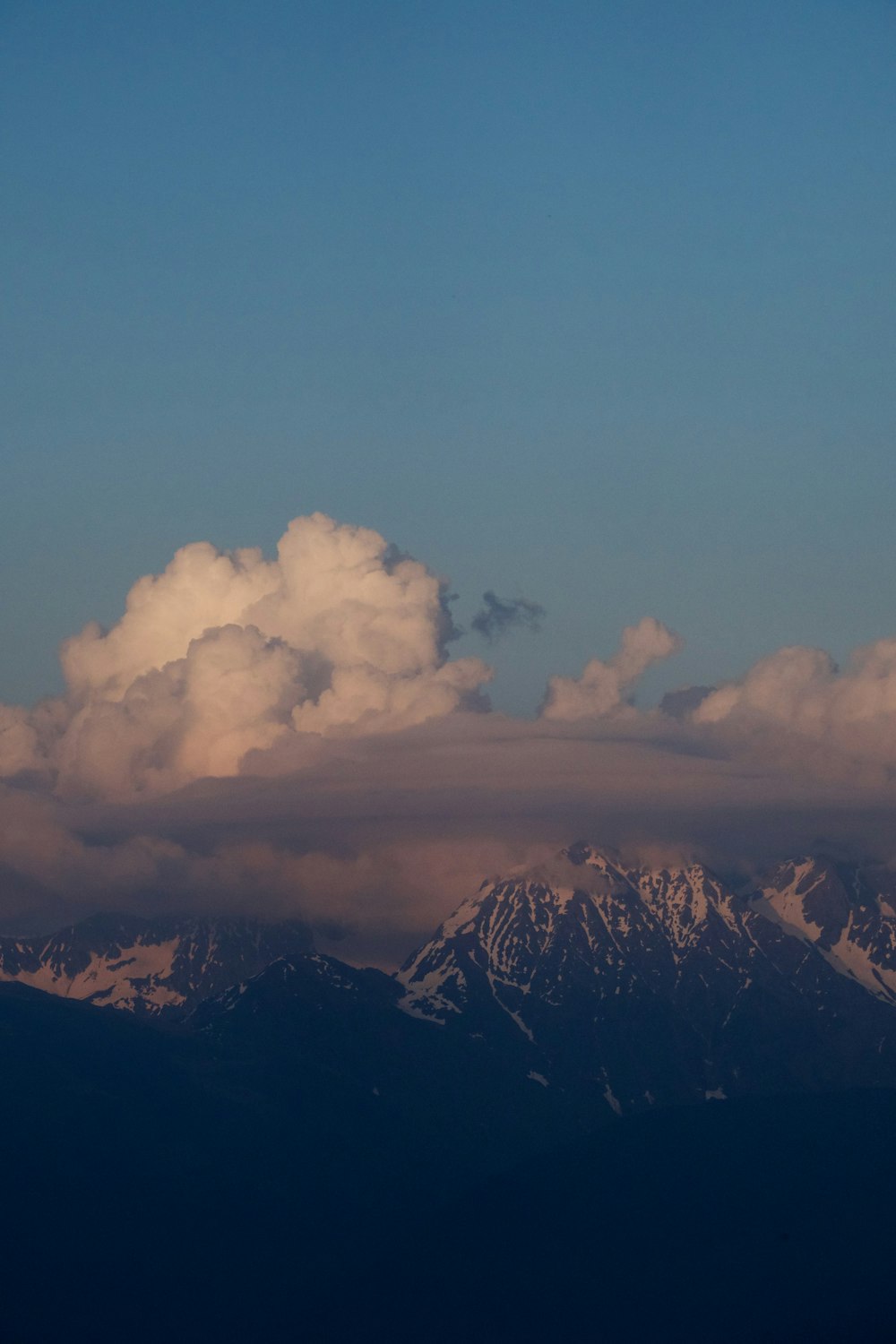 a view of a mountain range with clouds in the sky