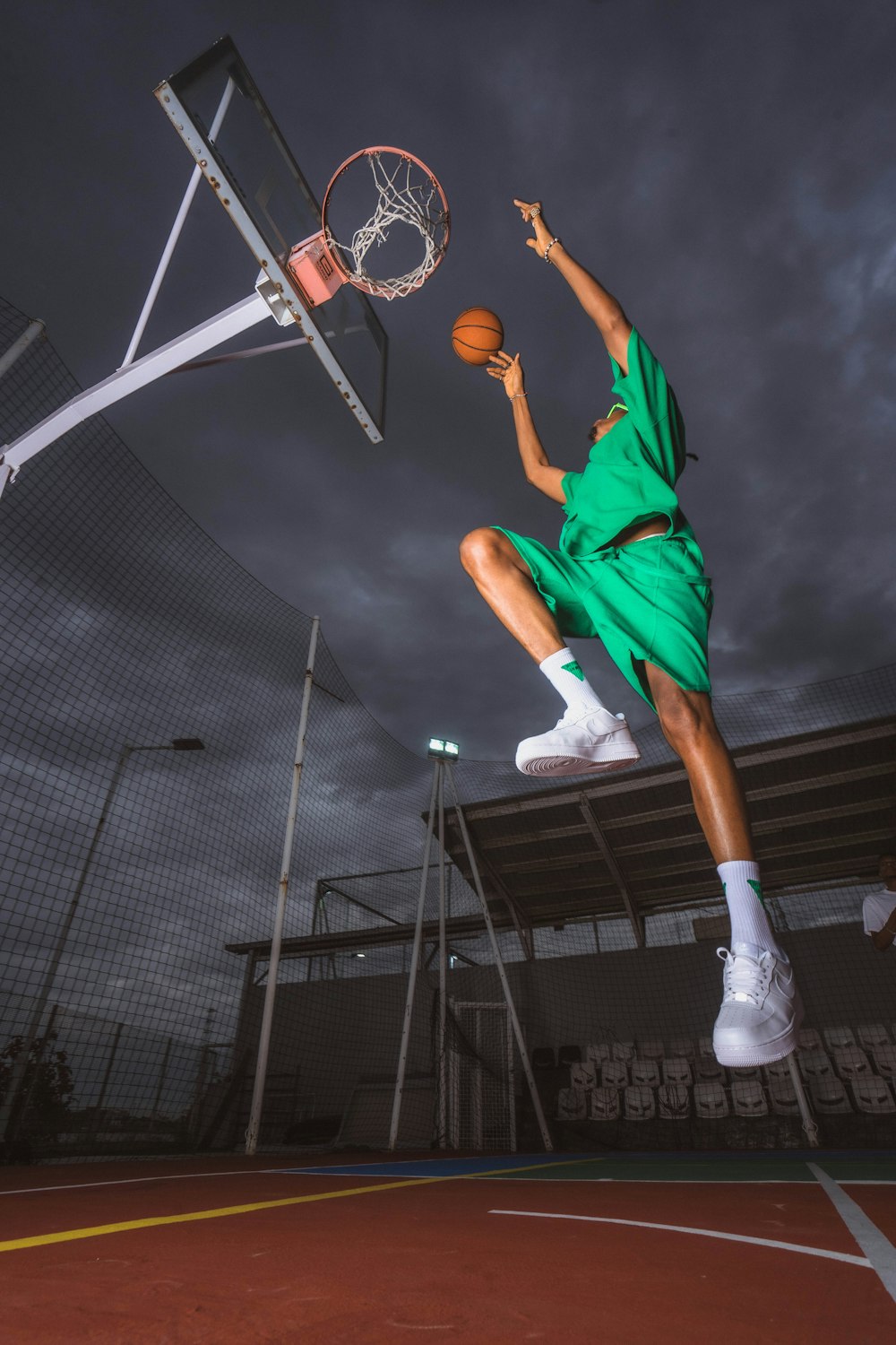 a man in a green shirt is playing basketball