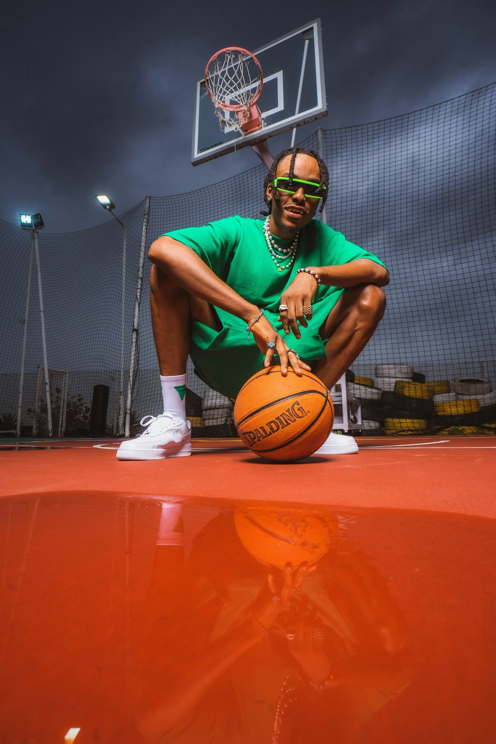 a man sitting on a basketball court holding a basketball