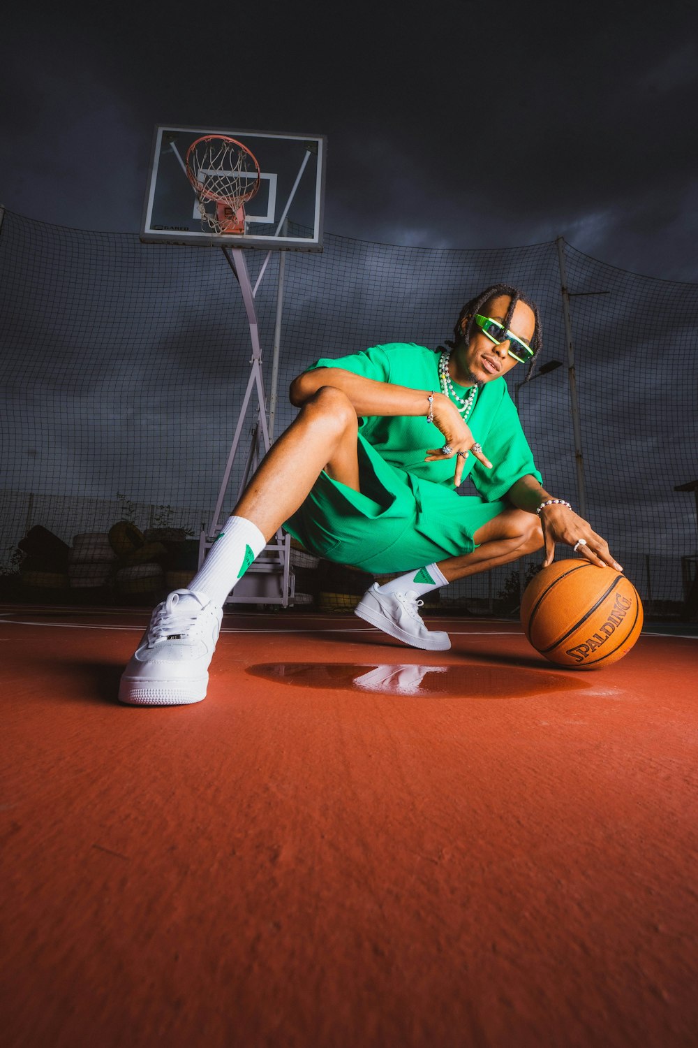 a man sitting on a basketball court holding a basketball