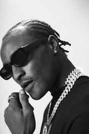 a man wearing sunglasses and a chain around his neck