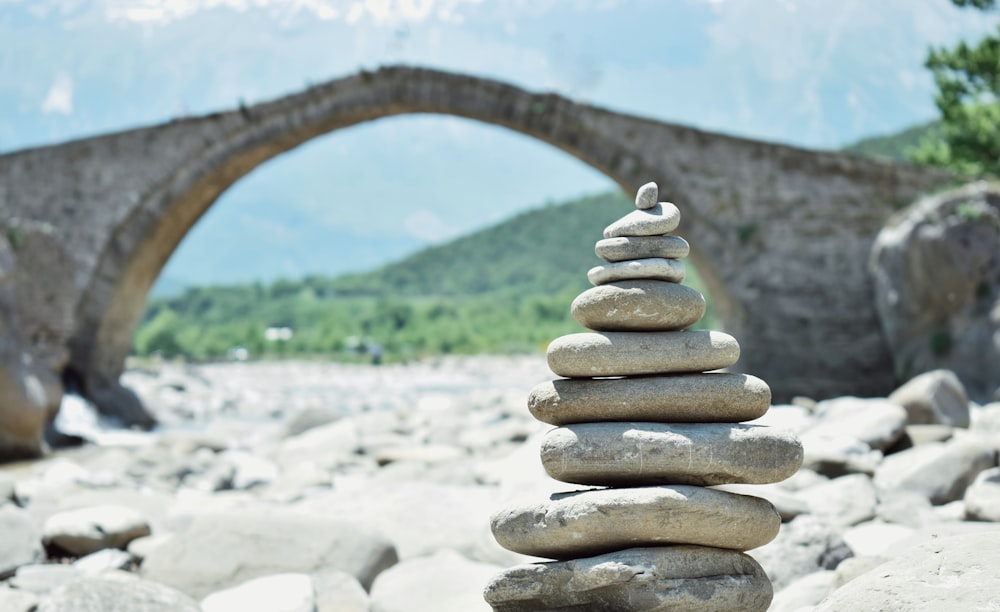 a pile of rocks sitting in front of a stone bridge