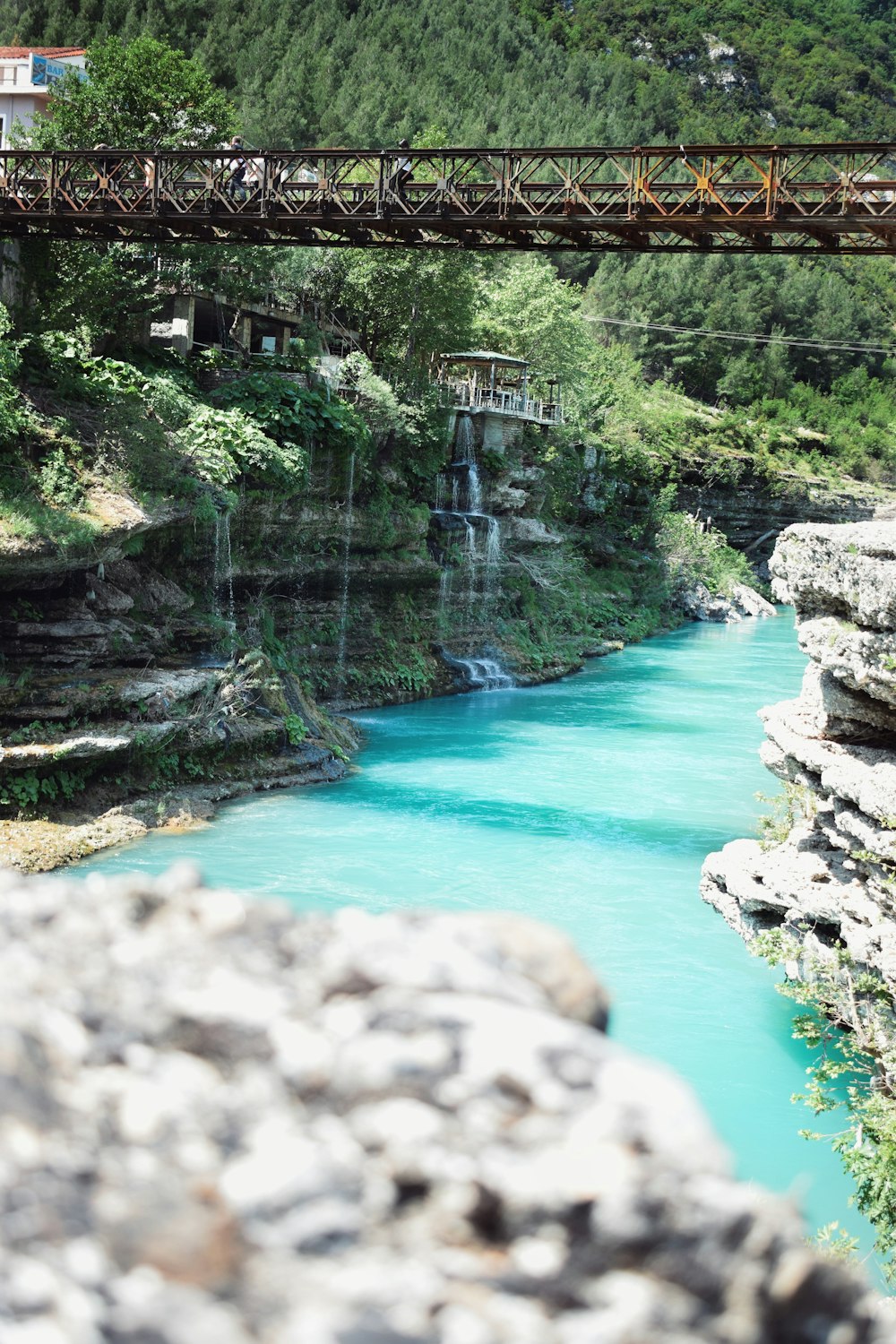 a bridge over a river with a waterfall below