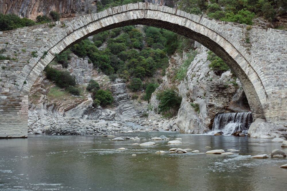 a stone bridge over a river with a waterfall