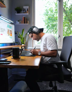 a man sitting at a desk working on a laptop