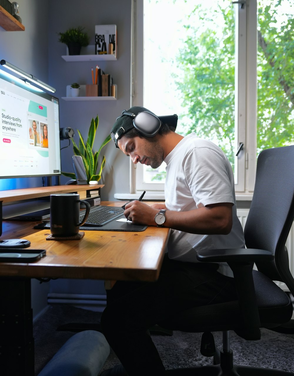 a man sitting at a desk working on a laptop