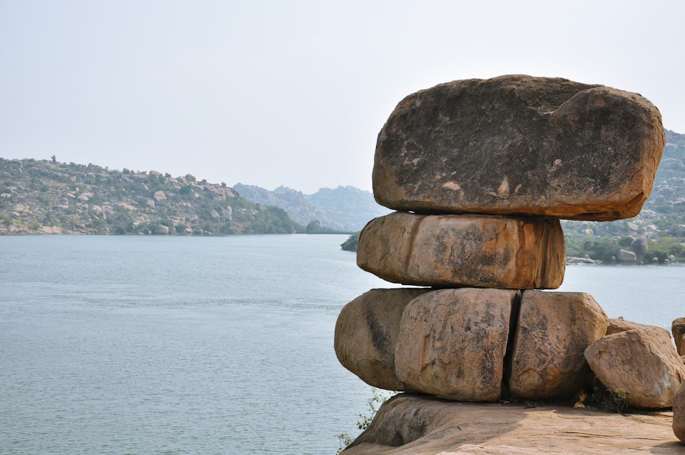 a stack of rocks sitting next to a body of water
