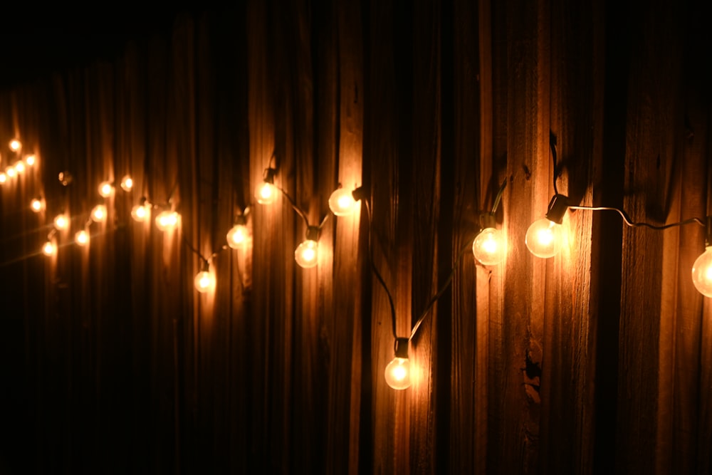 a string of lights hanging from a wooden wall
