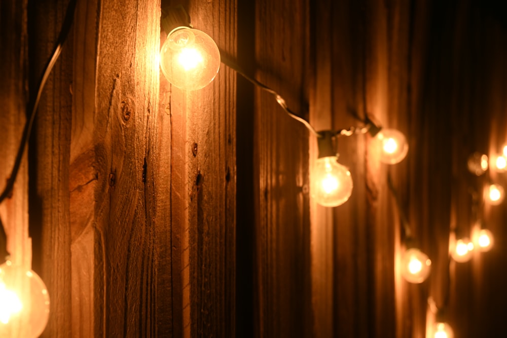a string of lights hanging from a wooden wall